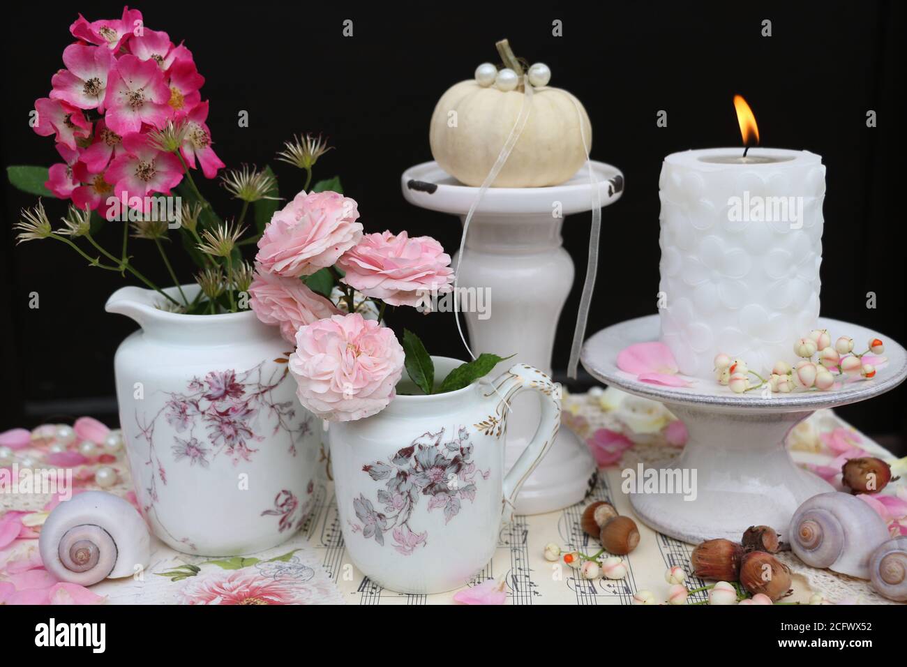 Romantische Herbstdekoration mit Vintage Porzellan. Rosenstrauß und Kerze Stockfoto