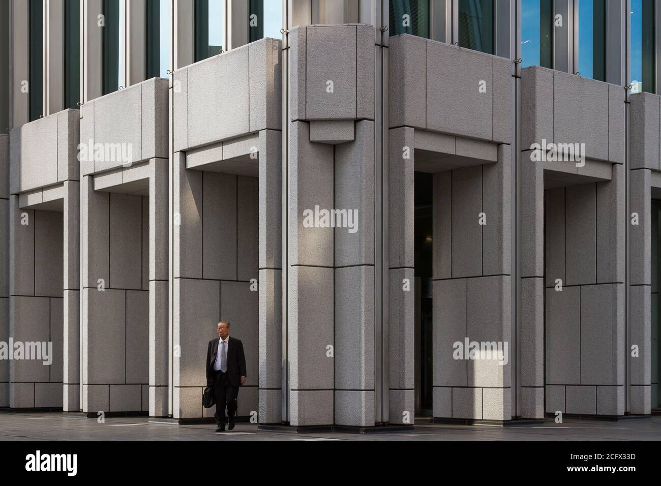Ein japanischer Salaryman verlässt ein Bürogebäude in Shinjuku, Tokio, Japan Stockfoto