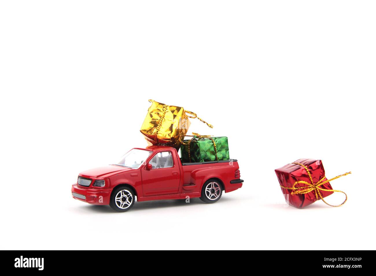 Helle eingewickelte Geschenke auf rotem Pickup isoliert auf weißem Hintergrund. Geschenkidee Stockfoto
