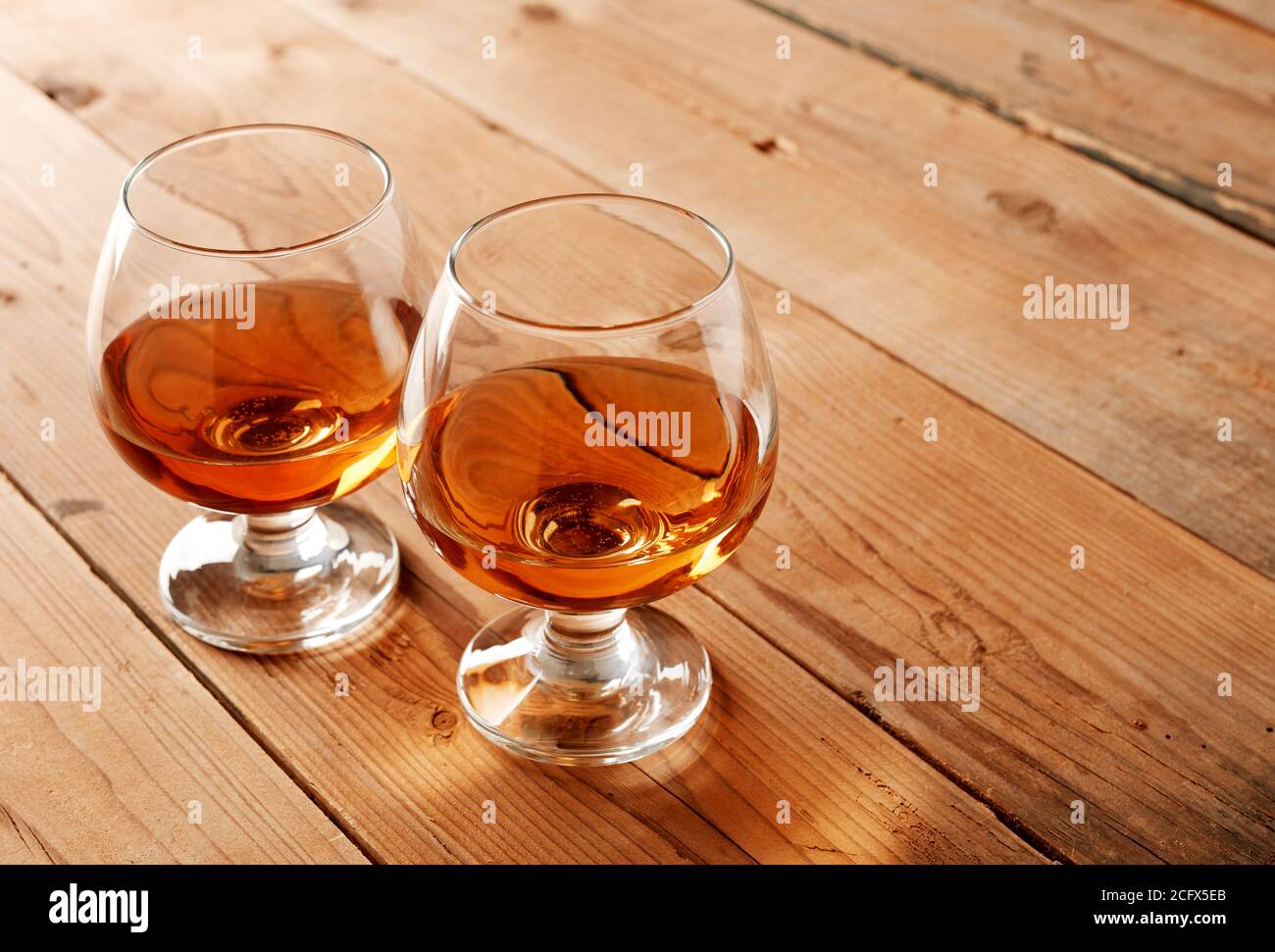 Gläser Cognac auf altem Holztisch Stockfoto