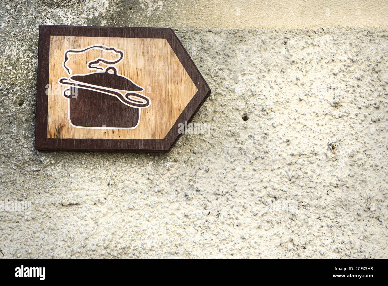 Ein Holzschild zeigt auf der rechten Seite ein Restaurant an Stockfoto