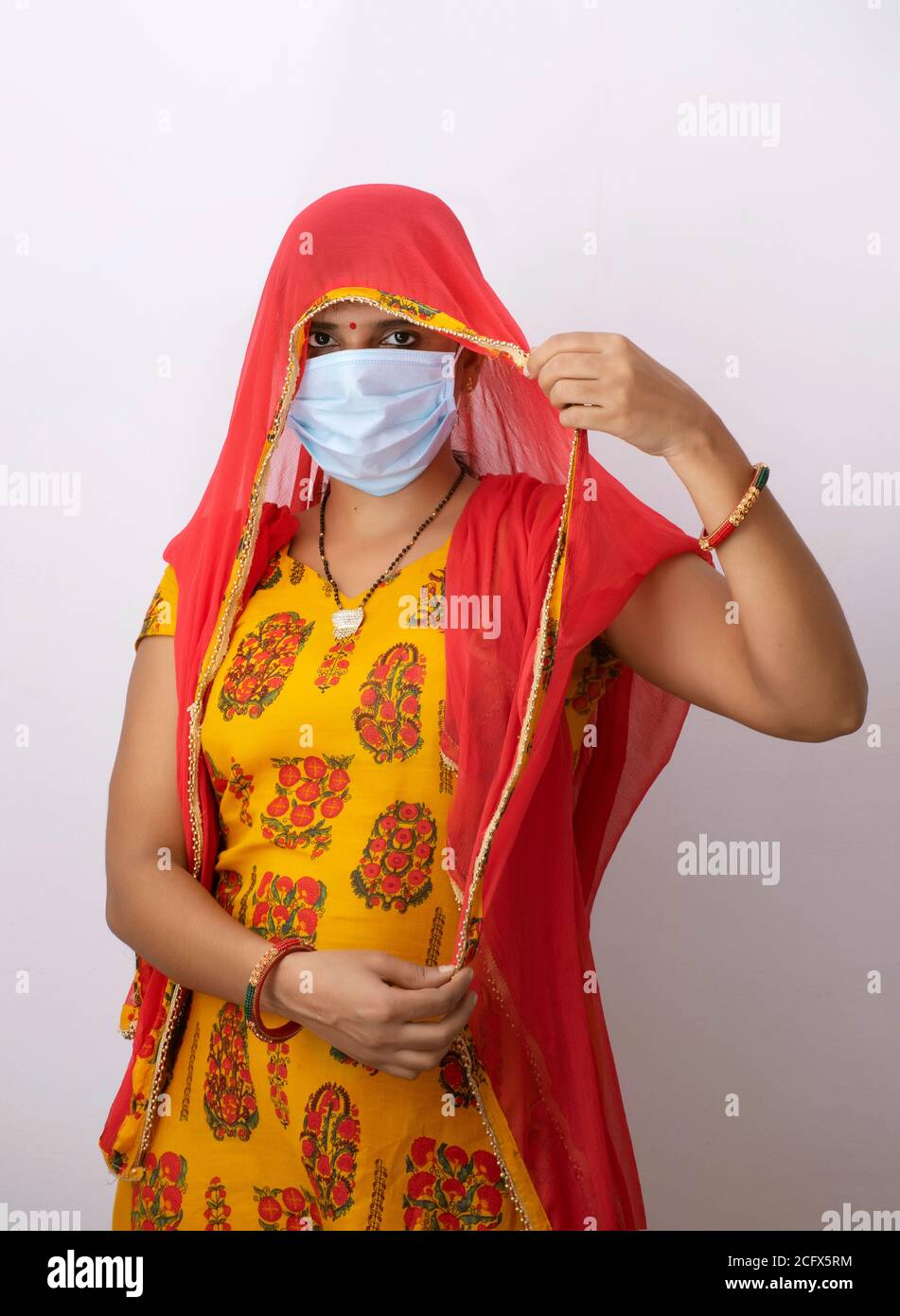 indische Frau trägt Maske Blick durch Schleier Stockfoto