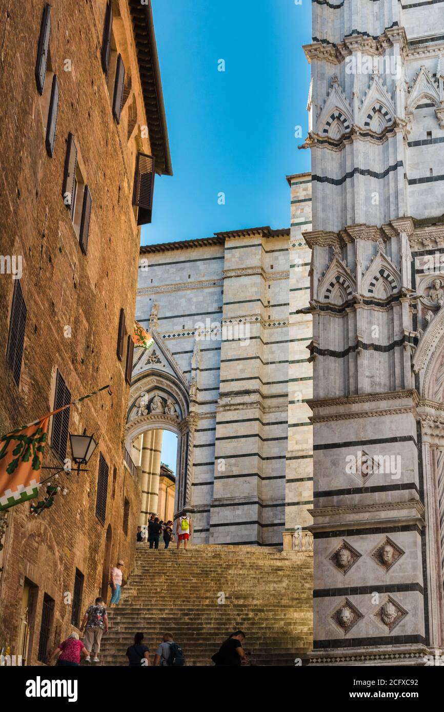 Schöne Aussicht auf eine steile Treppe, die zum Seitenportal Porta laterale del Duomo Nuovo von der Piazza San Giovanni führt; als Durchgang zwischen... Stockfoto