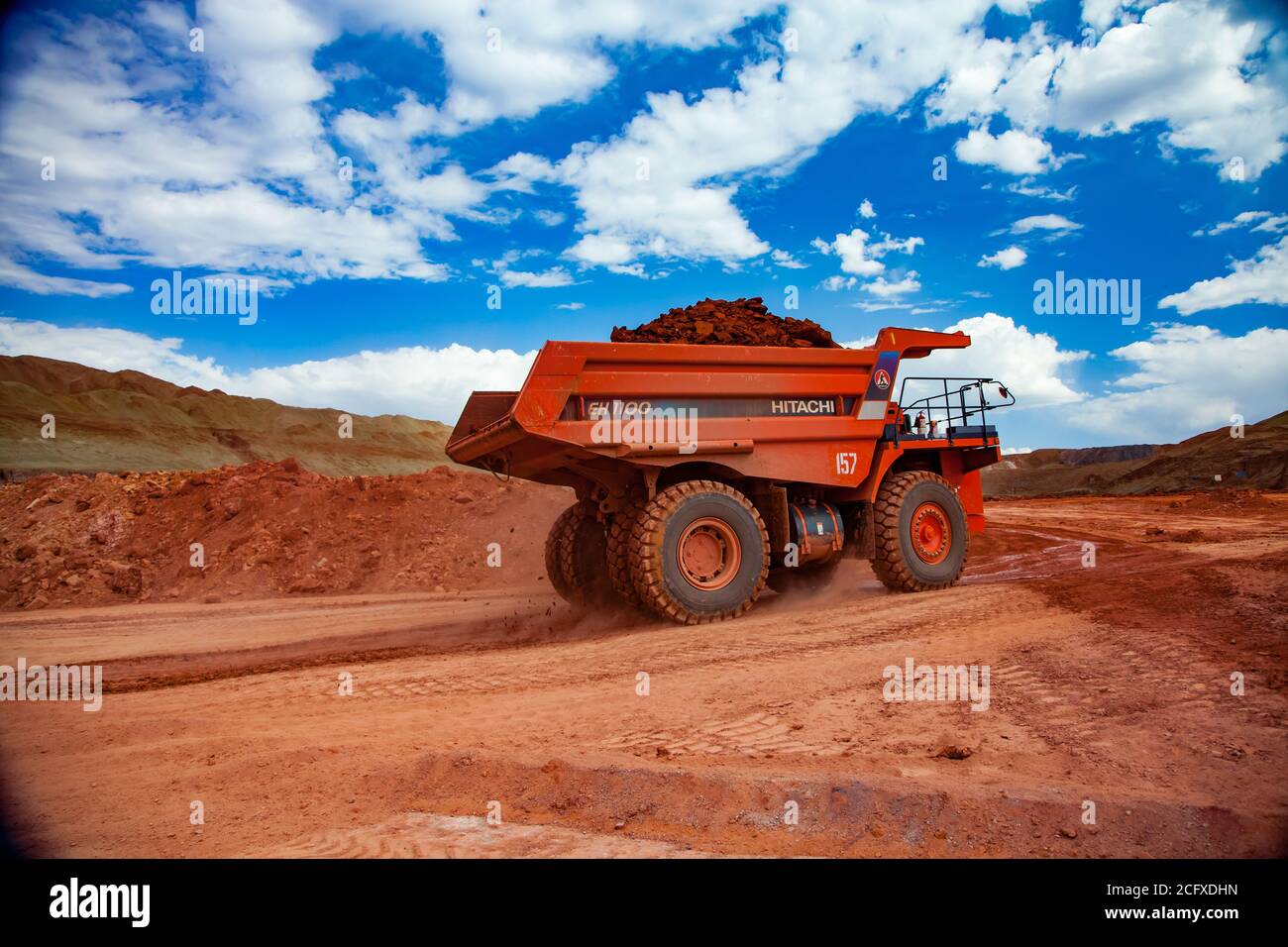 Aluminiumerz Bergbau und Transport.. Tagebau (Steinbruch). Orange Hitachi Steinbruch Kipper mit Bauxit Ton. Stockfoto