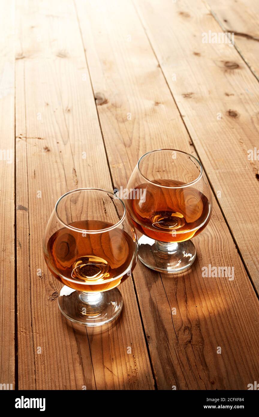 Gläser Cognac auf altem Holztisch Stockfoto