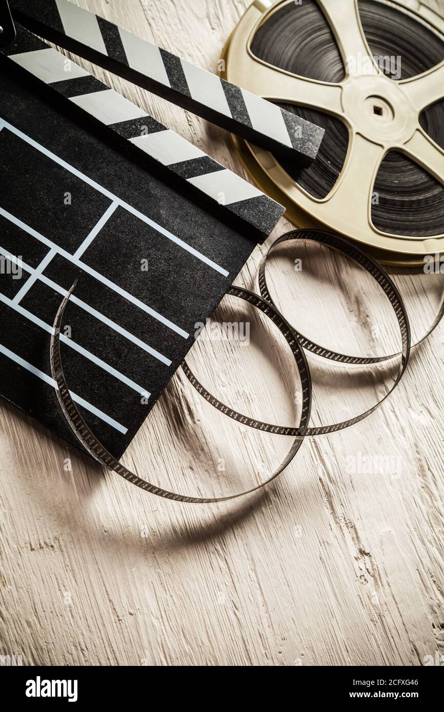 Vintage film claper mit Filmrolle auf Holz gelegt. Filmammakers Ausrüstung Hintergrund Stockfoto