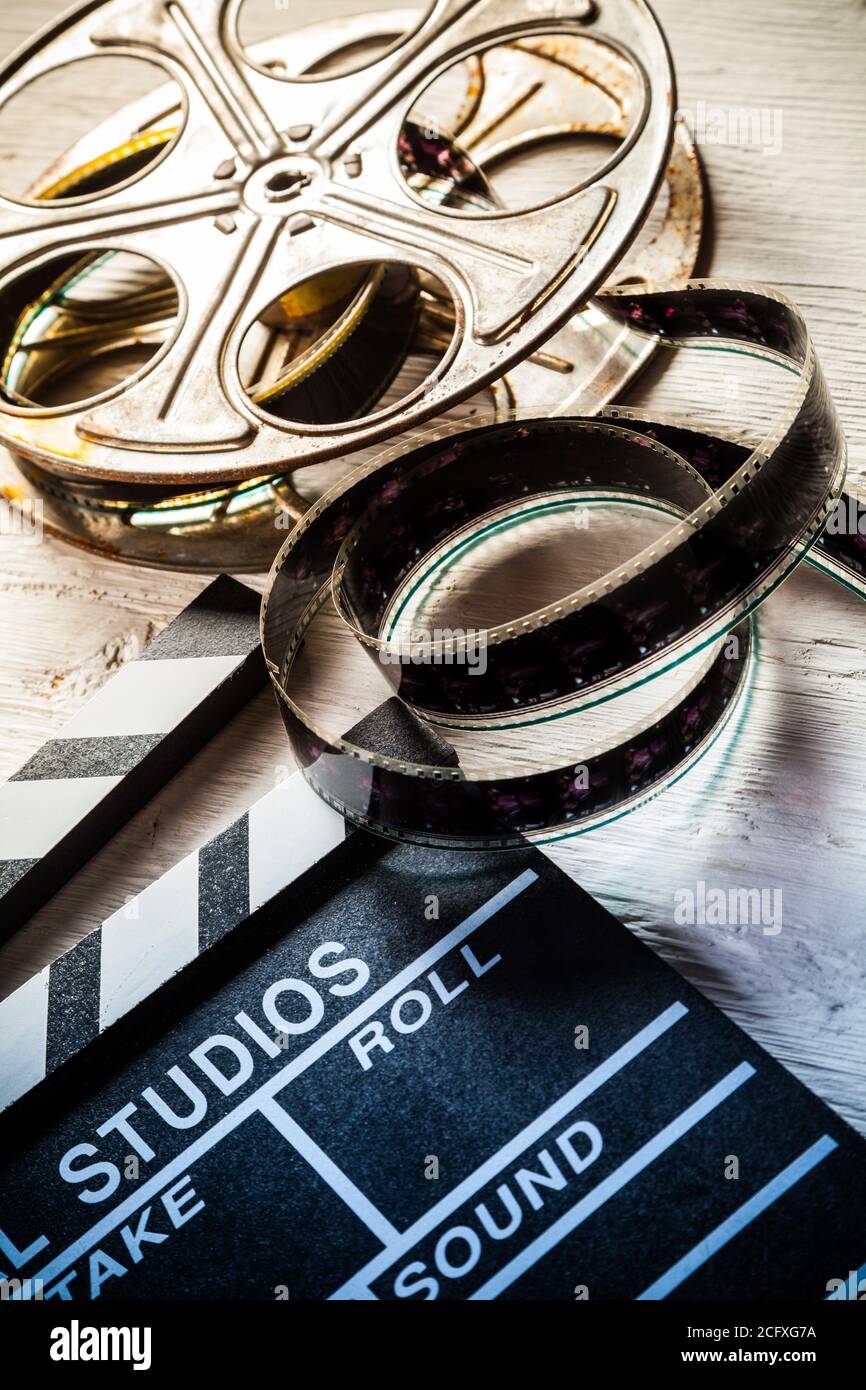 Vintage film claper mit Filmrolle auf Holz gelegt. Filmammakers Ausrüstung Hintergrund Stockfoto