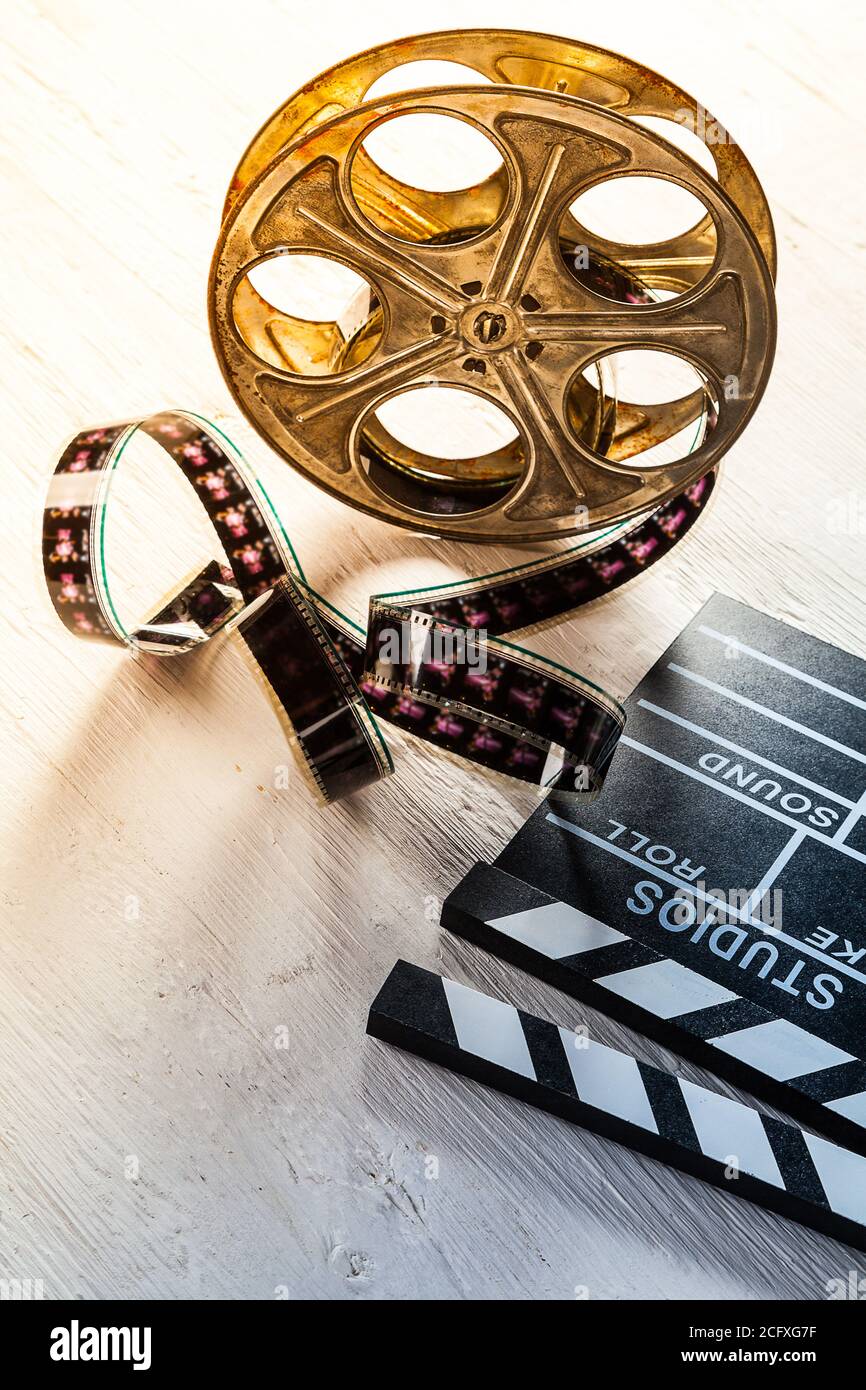 Vintage film claper mit Filmrolle auf Holz gelegt. Filmammakers Ausrüstung Hintergrund Stockfoto