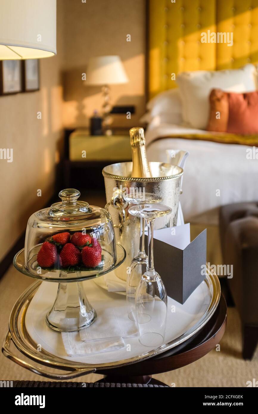 Ein Teller Erdbeeren und eine Flasche Champagner erwarten die Gäste in einem luxuriösen Hotelzimmer in Hongkong. Stockfoto