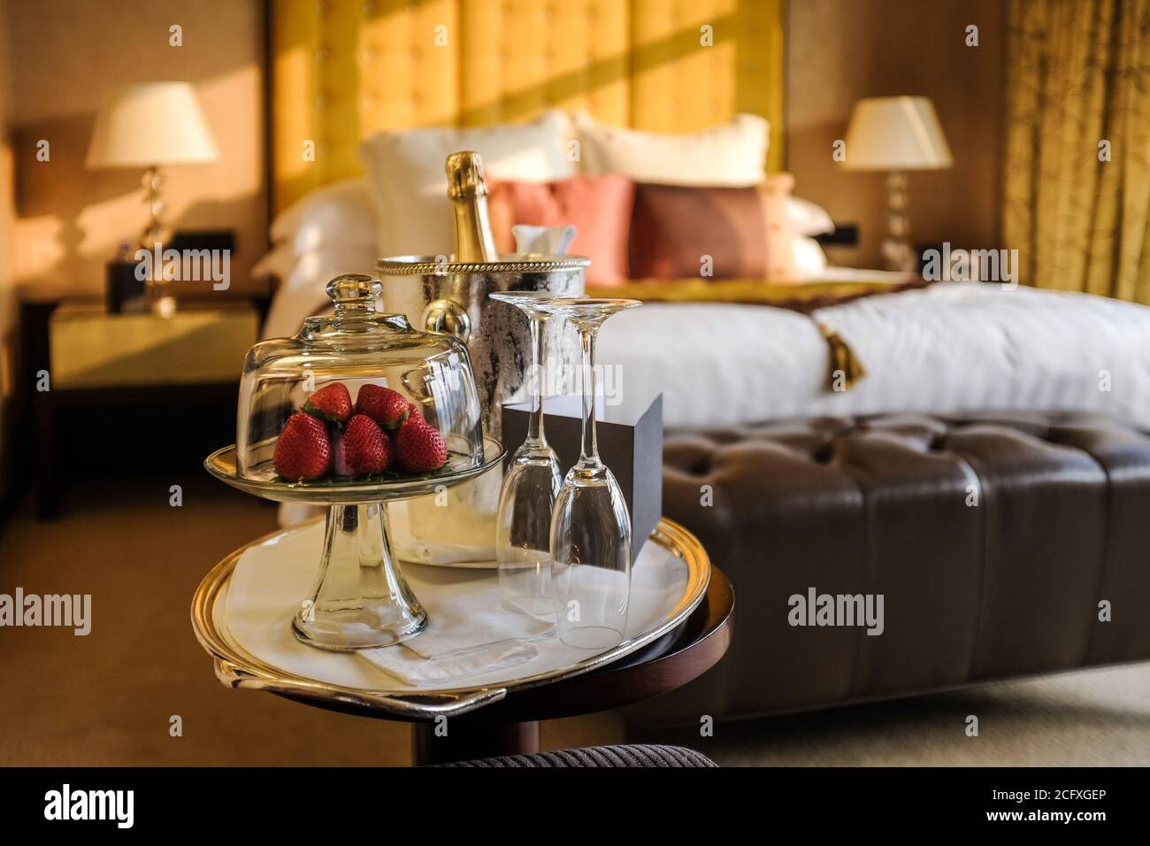 Ein Teller Erdbeeren und eine Flasche Champagner erwarten die Gäste in einem luxuriösen Hotelzimmer in Hongkong. Stockfoto