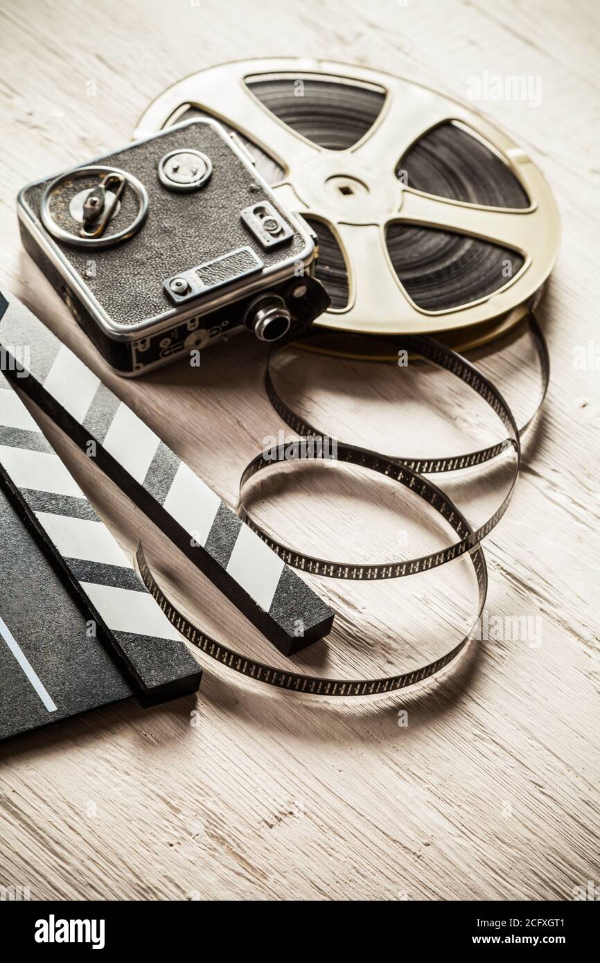 Vintage film claper mit Filmrolle auf Holz gelegt. Filmammakers Ausrüstung Hintergrund Stockfoto