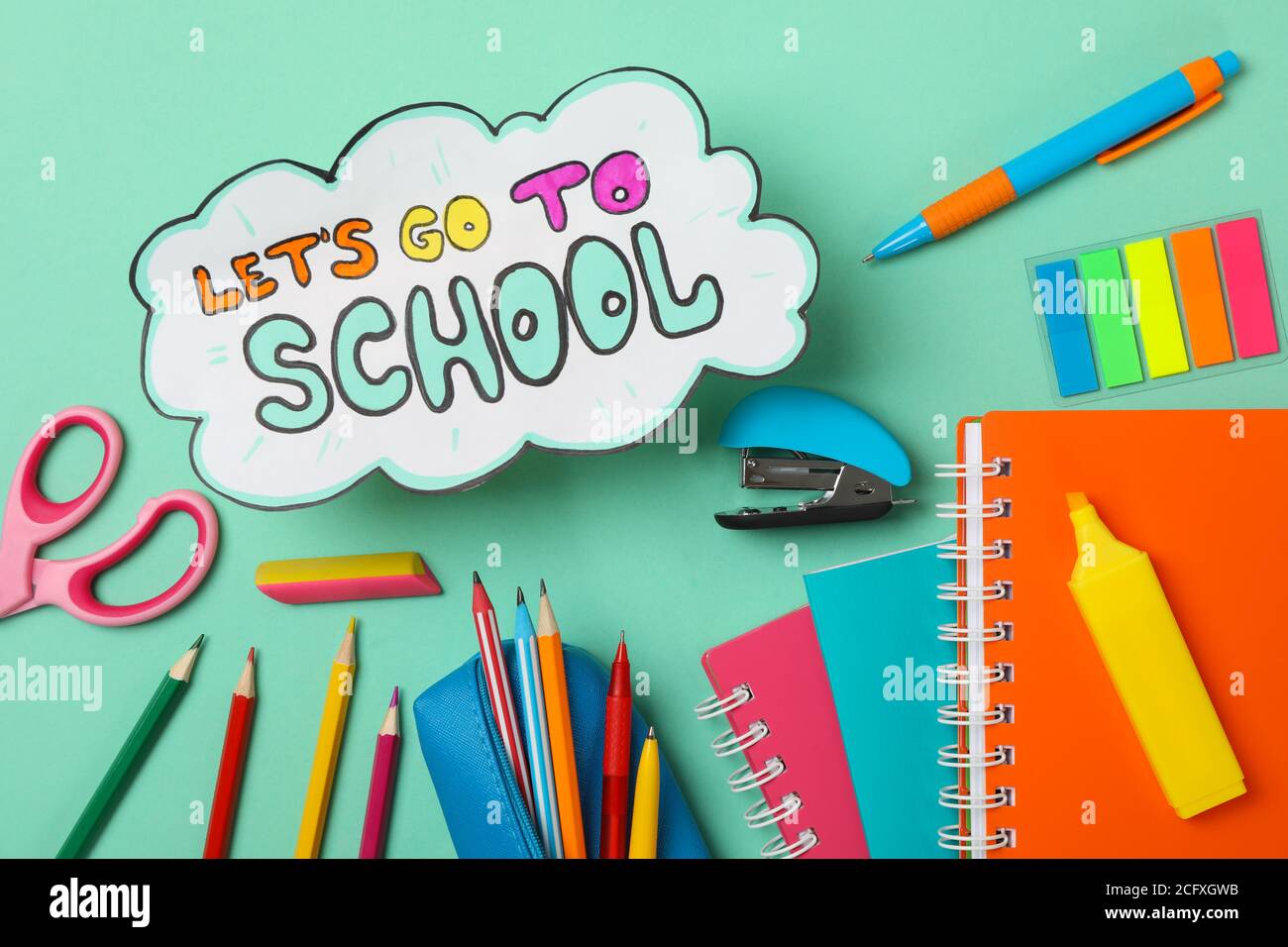 Text Gehen wir zur Schule und Schulbedarf auf MINT-Hintergrund Stockfoto