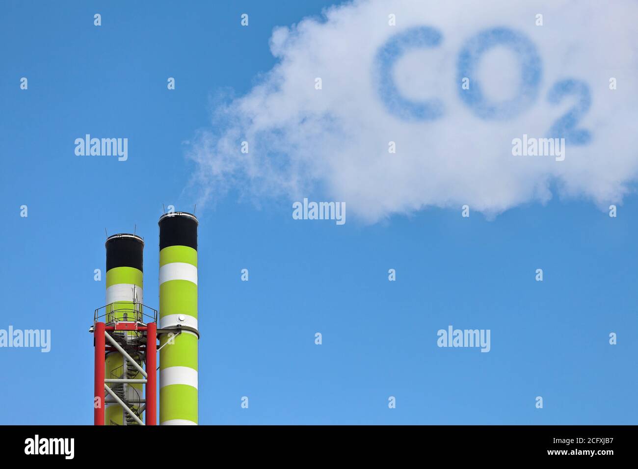 Grüne Fabrikrohre mit symbolischer Emission einer co2-Wolke Stockfoto