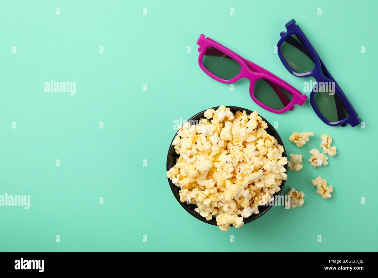 Schale mit Popcorn und 3d-Brille auf Minzhintergrund, Draufsicht Stockfoto