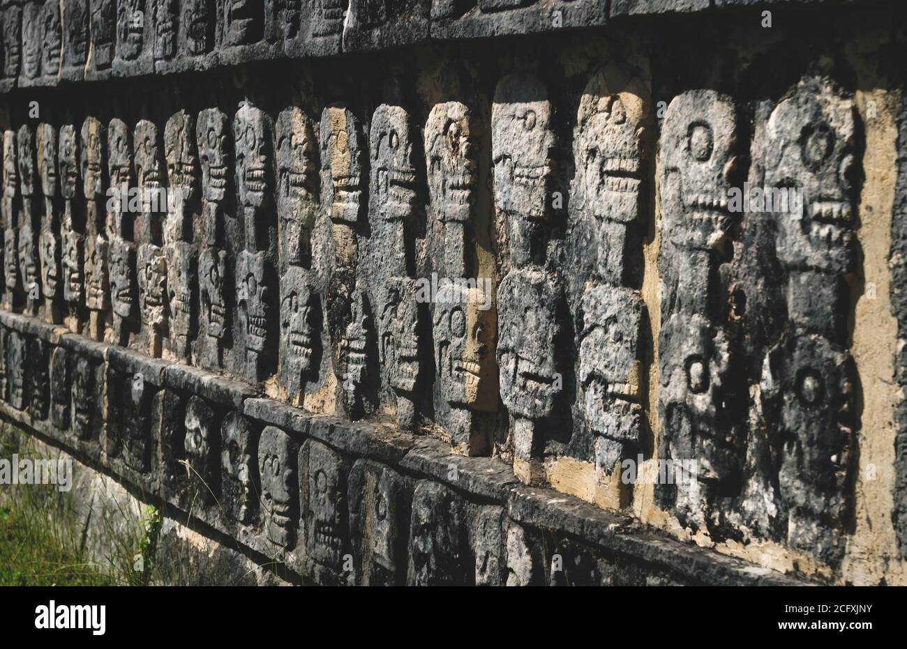 Wand mit geschnitzten Schädeln in einem Maya-Tempel aus Stein in Chichen Itza, Yucatan, Mexiko Stockfoto