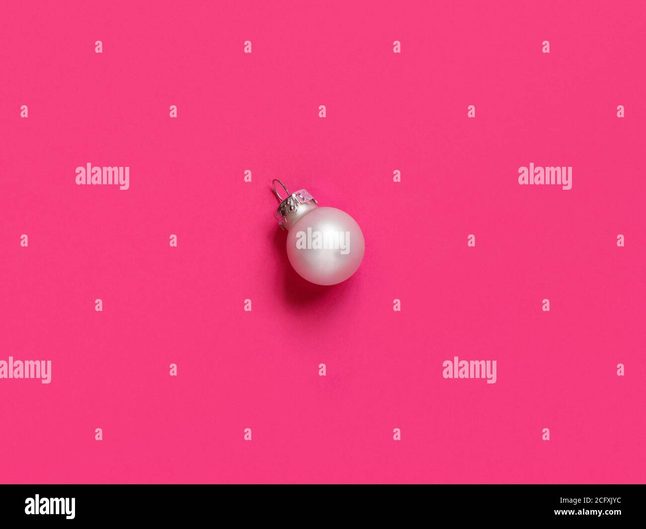 Silberne Weihnachtskugel auf einem rosa Hintergrund Draufsicht Stockfoto