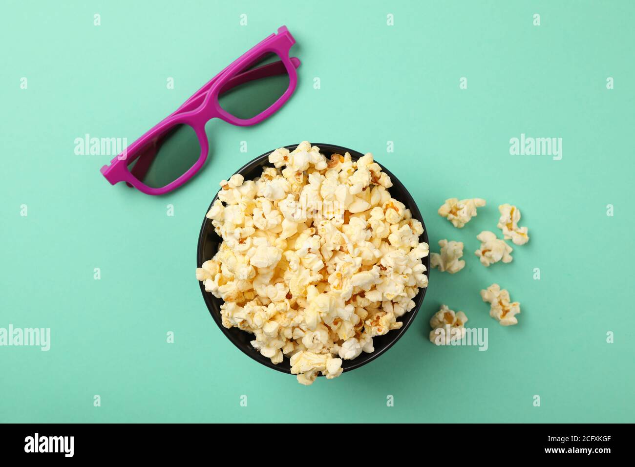 Schale mit Popcorn und 3d-Brille auf Minzhintergrund, Draufsicht Stockfoto