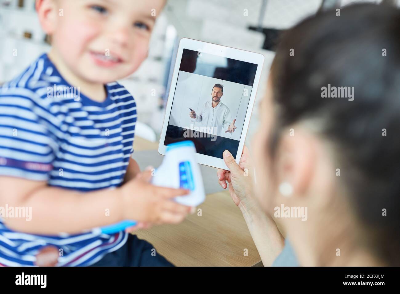 Mutter mit Kind im Video-Chat als Online-Beratung mit Ein Kinderarzt Stockfoto