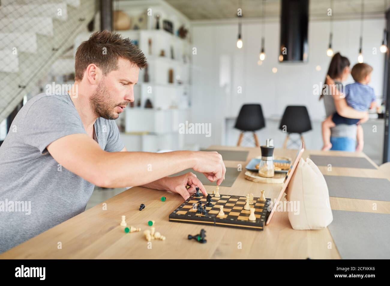 Mann, der zu Hause im Wohnzimmer Schach spielt Video-Chat online Stockfoto