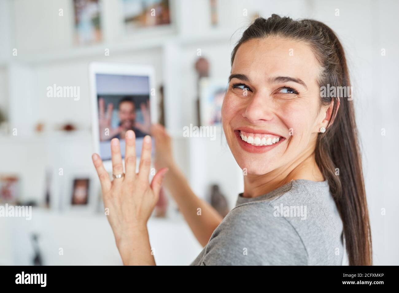 Junge Frau glücklich Wellen während Video-Chat online mit ihr Partner für Ferngespräche Stockfoto
