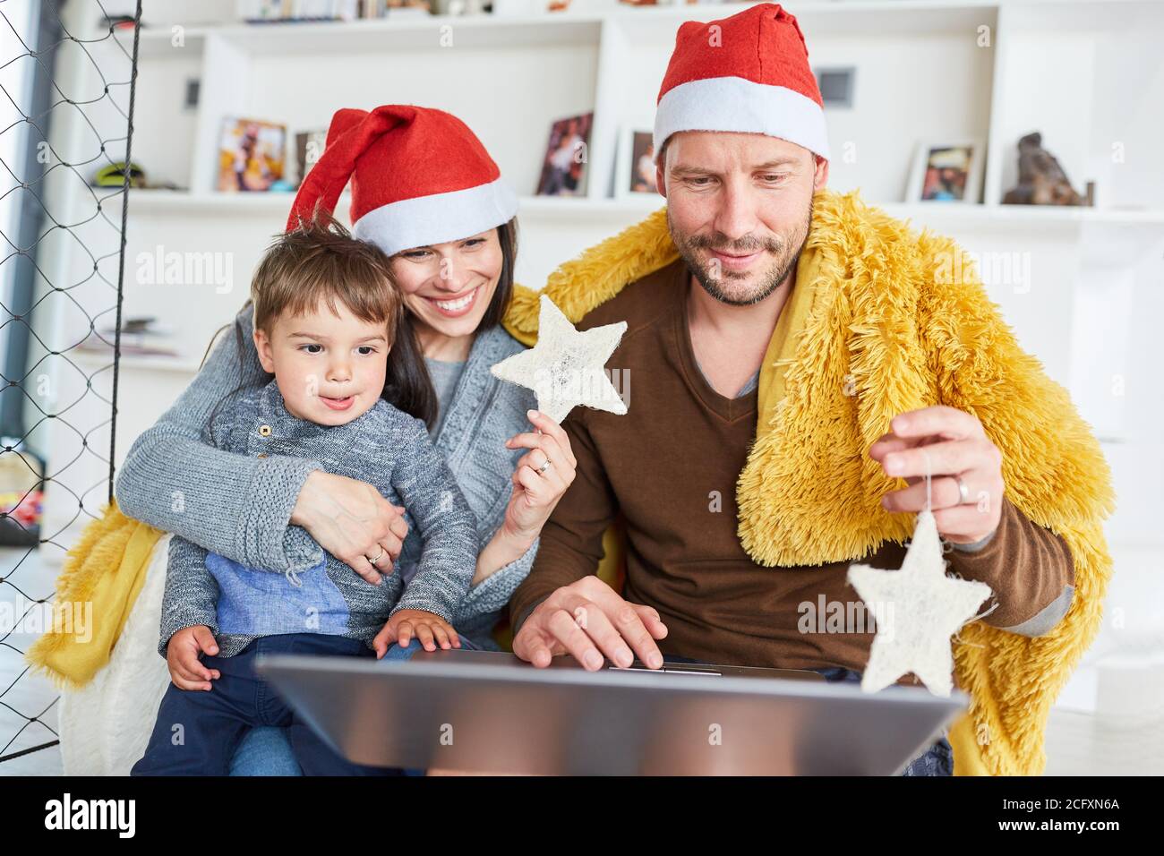 Eltern und Kinder feiern Weihnachten, indem sie zu Hause Videos streamen Im Wohnzimmer Stockfoto