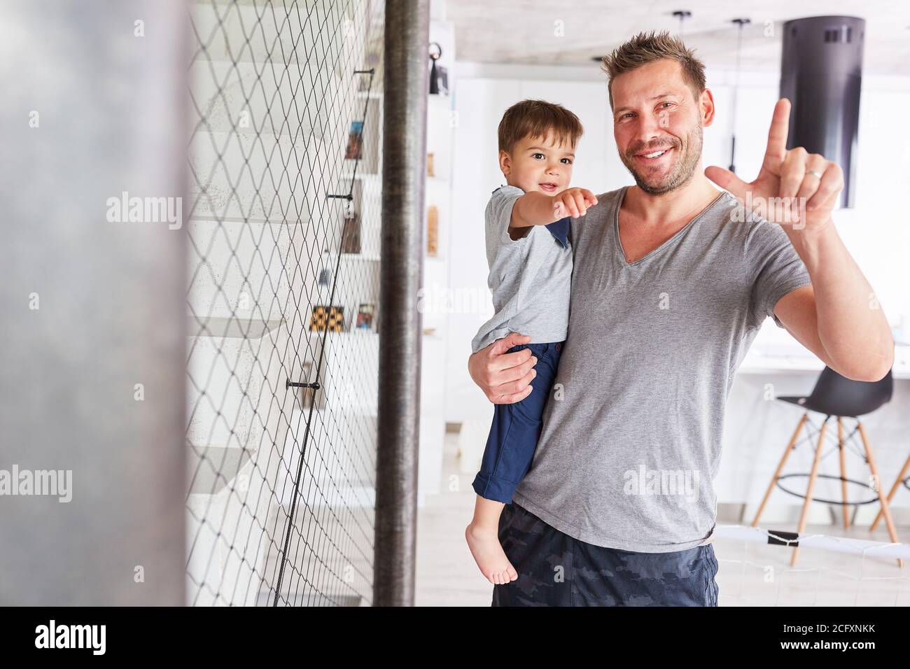 Glücklicher Vater trägt seinen Sohn in seinen Armen zur Pflege Und die alleinerziehende Erziehung Stockfoto