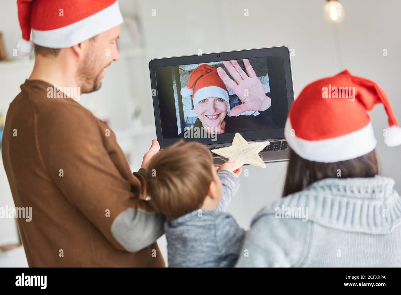 Oma beim Video-Chat mit der Familie zu Weihnachten Im Wohnzimmer Stockfoto