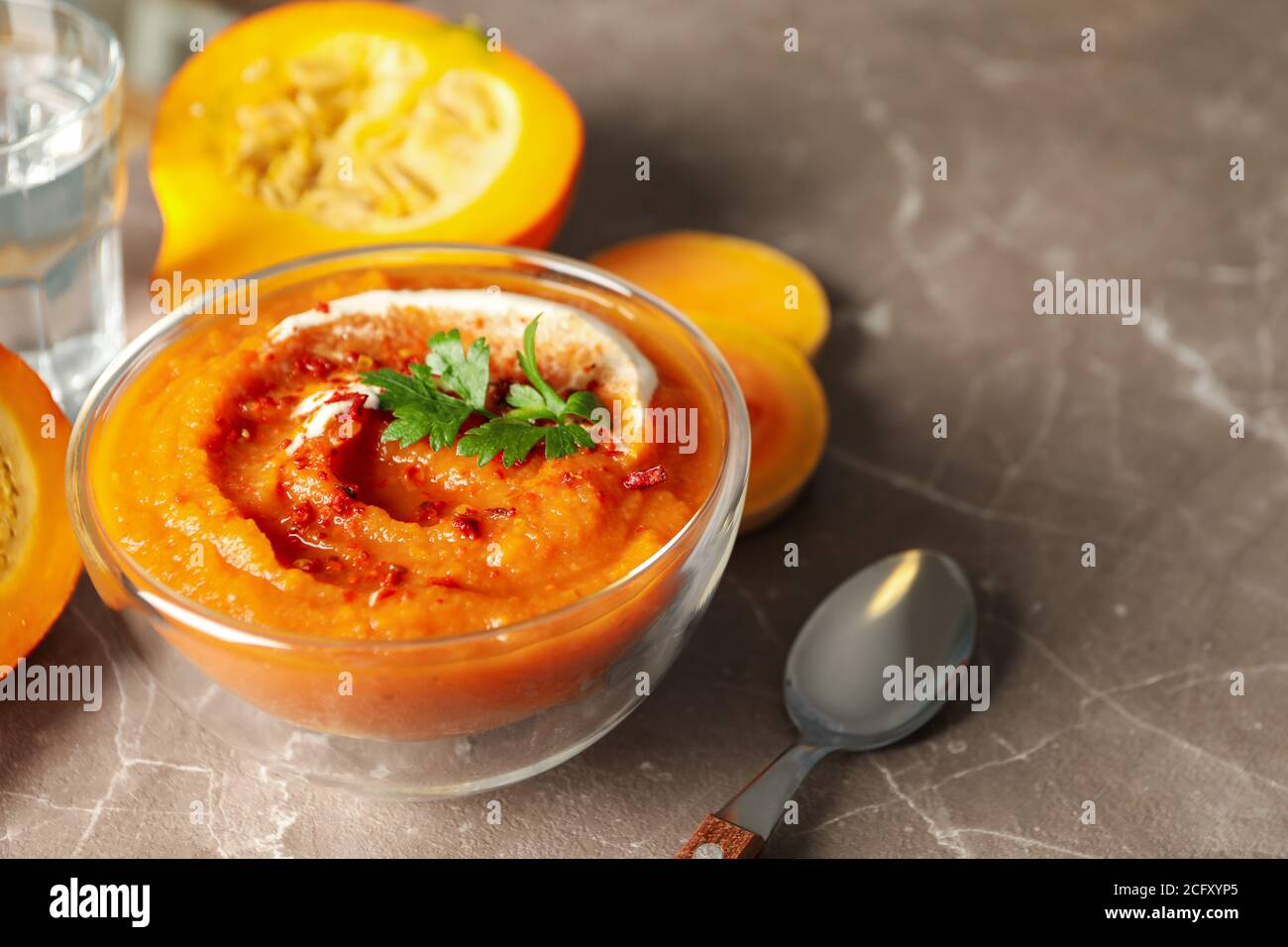 Schüssel mit Kürbissuppe auf Grau mit Platz für Text, eine moderne Herbstrezeptkomposition Stockfoto
