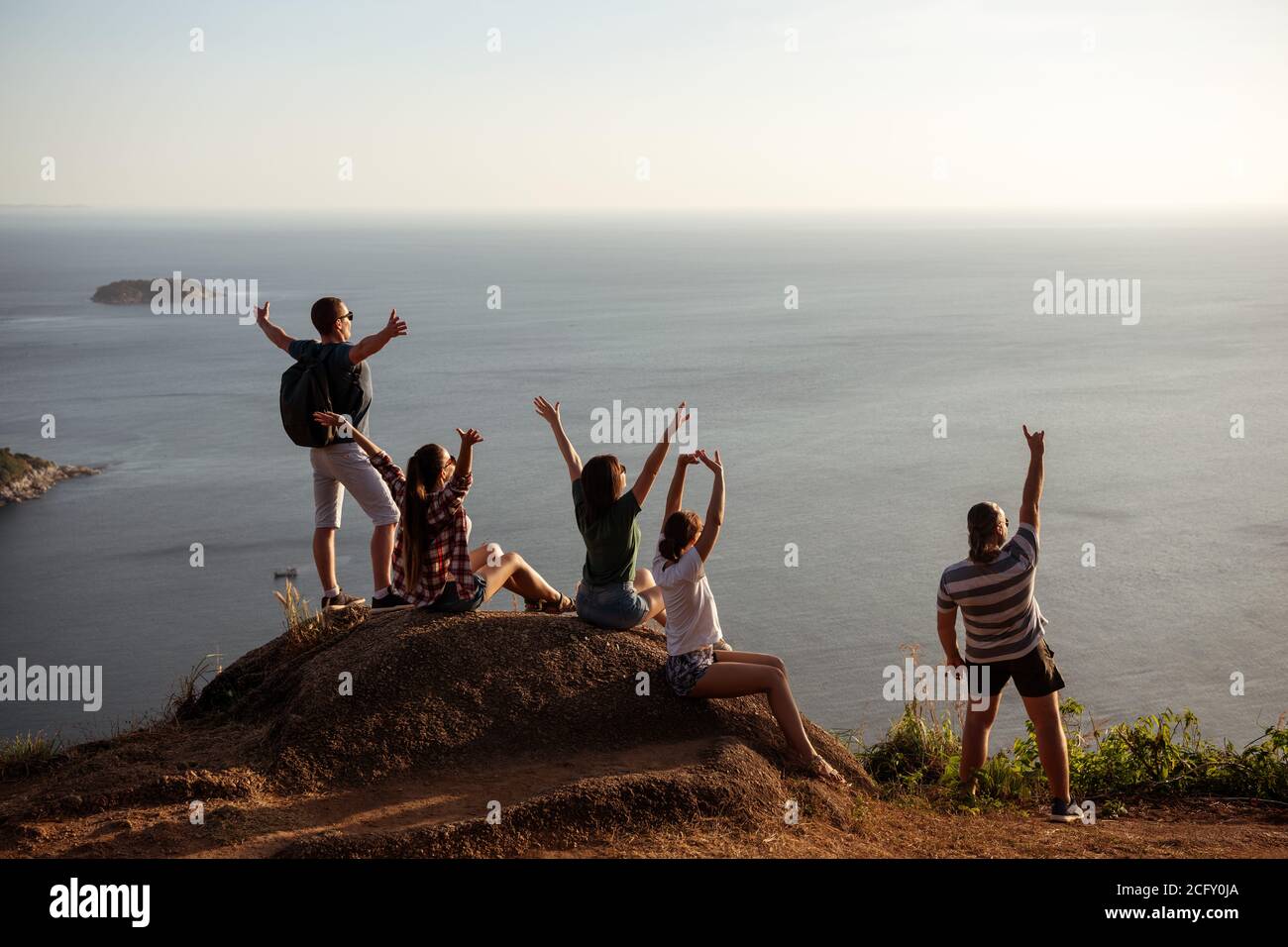 Fünf glückliche Freunde haben Spaß und genießen den Sonnenuntergang Meerblick Stockfoto