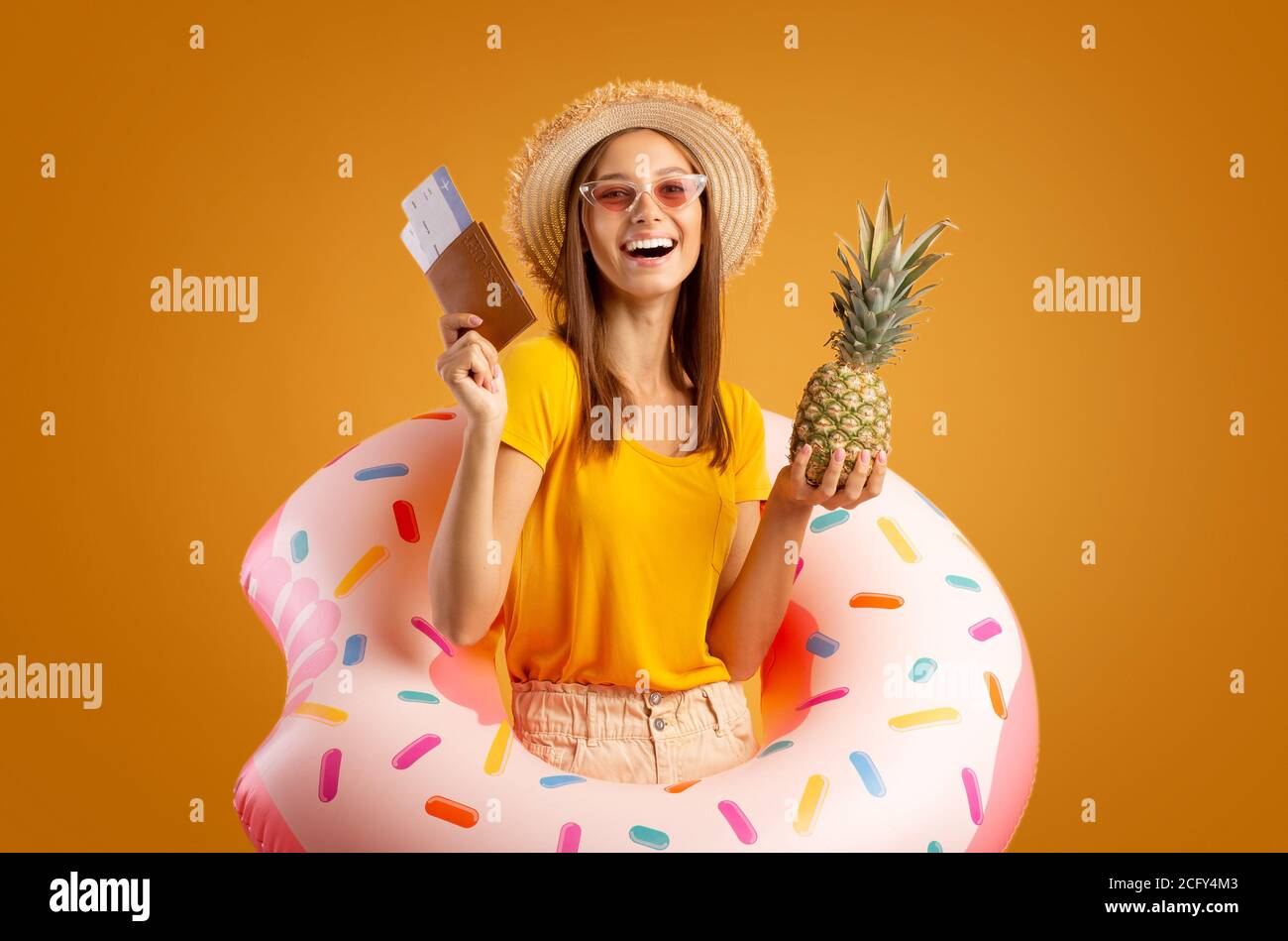 Emotionale Mädchen mit Ananas und Pass trägt Gummiring Stockfoto