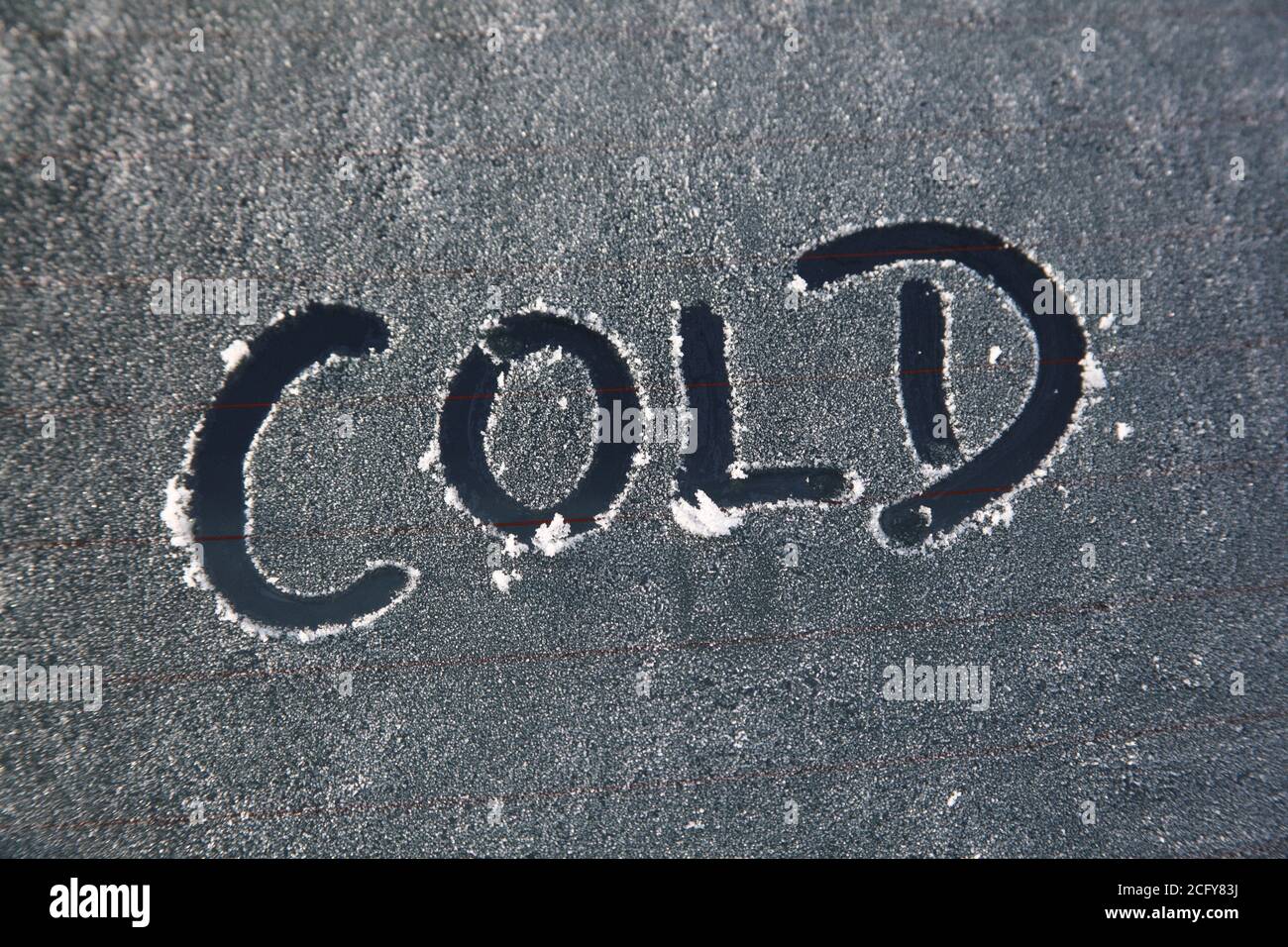 Frost und Schnee auf einem Autoglasfenster mit einem Kalt eiskalt Winter schlechtes Wetter Nachricht Text Zeichen Stock Foto Bild Stockfoto