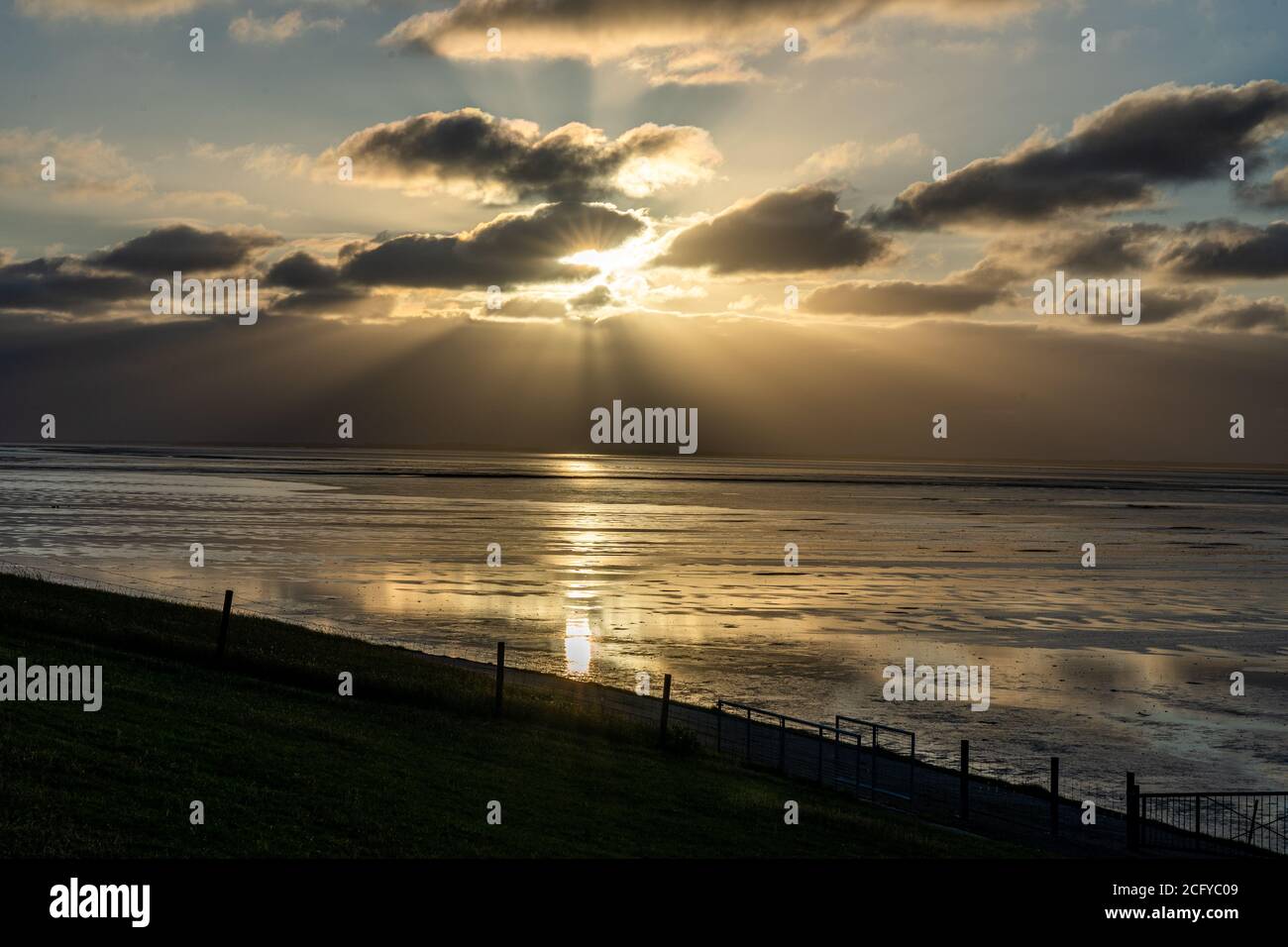 Blick auf das wattenmeer der Nordsee bei Ebbe bei Sonnenuntergang bei bernersiel, deutschland Stockfoto