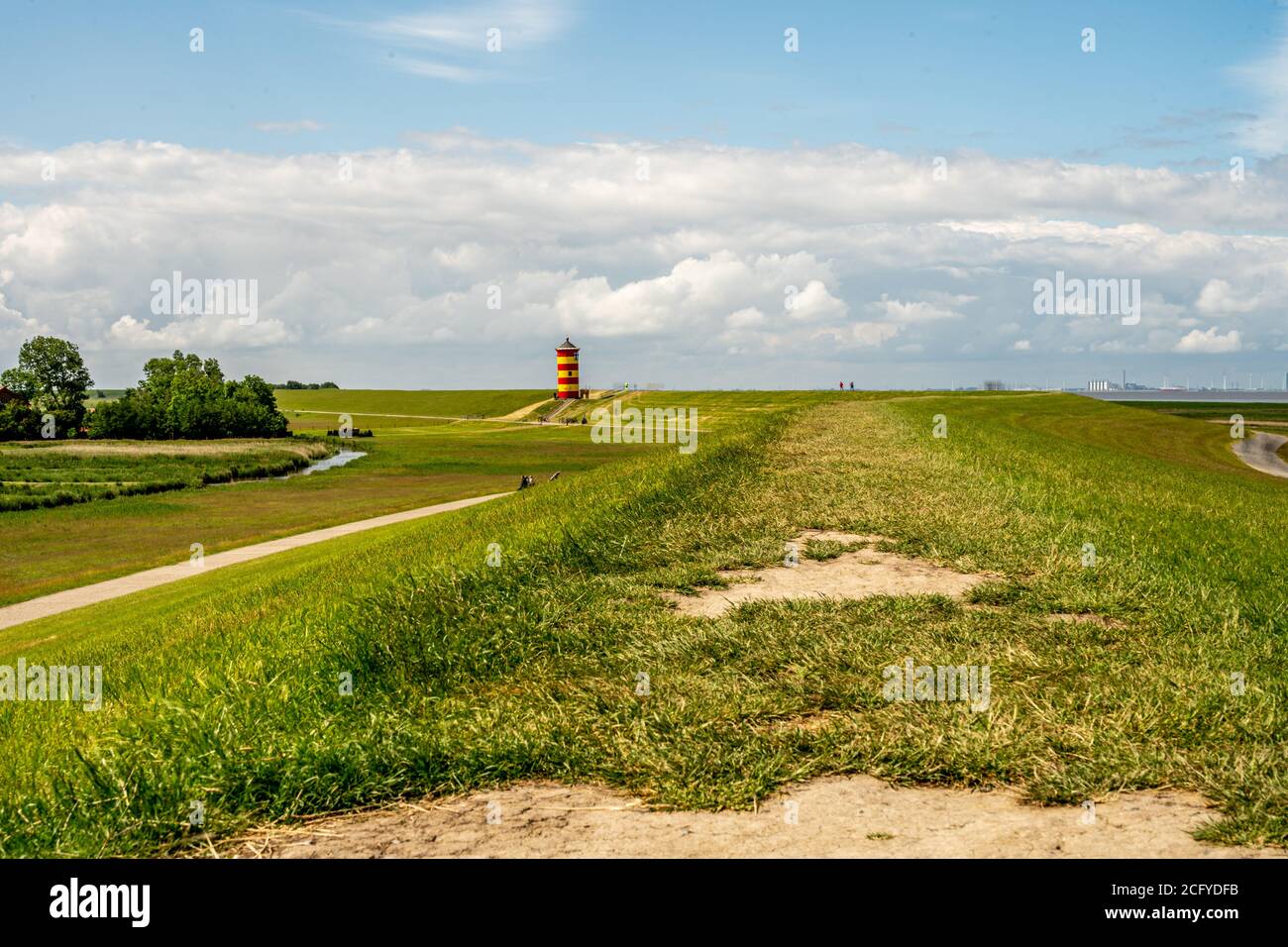 Blick auf Pilsum Leuchtturm in Ostfriesland mit Touristen zu Fuß Rund um den Deich und Fotografieren Stockfoto