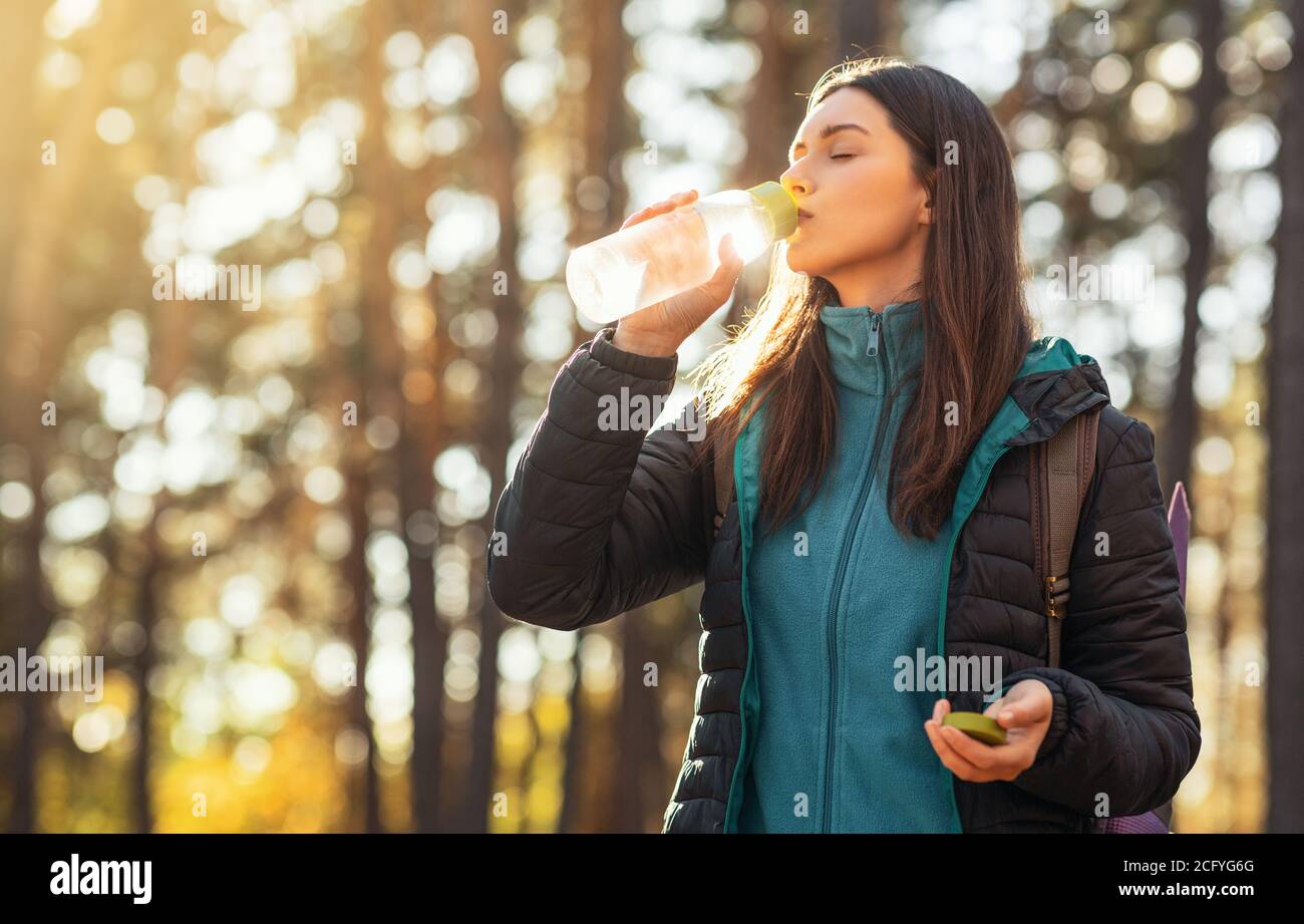 Durstige Mädchen Trinkwasser beim Wandern durch den Wald Stockfoto
