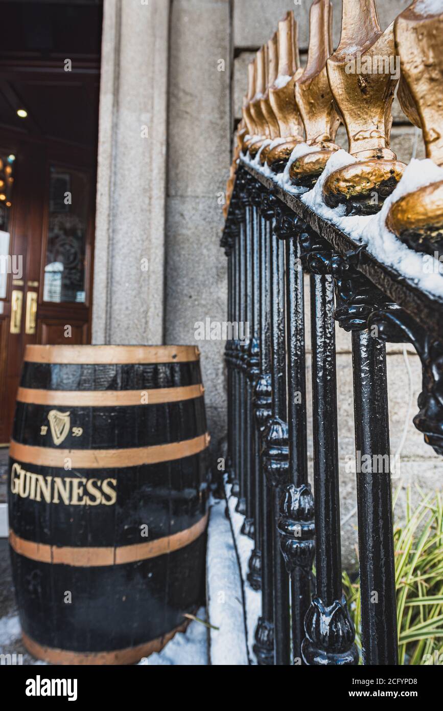 Traditioneller irischer spitzer, schwarzer Handlauf mit einem Guinness-Bierfass am Eingang eines Pubs. Typisch irischer schwarzer Zaun mit Bierfass Stockfoto