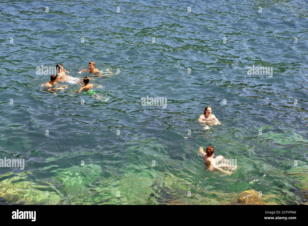 Hochwinkel-Ansicht einer kleinen Gruppe von Menschen schwimmen und Abkühlung im Meer in einem Sommertag, Porto Venere, La Spezia, Ligurien, Italien Stockfoto