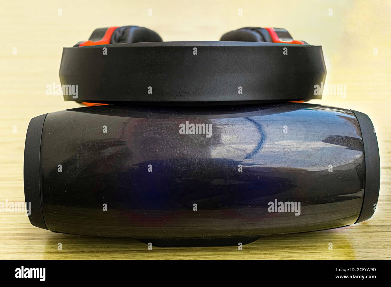 Ein Lautsprecher mit bluetooth- und AUX-Verbindung, über den ein Kopfhörer gehalten wird. Stockfoto