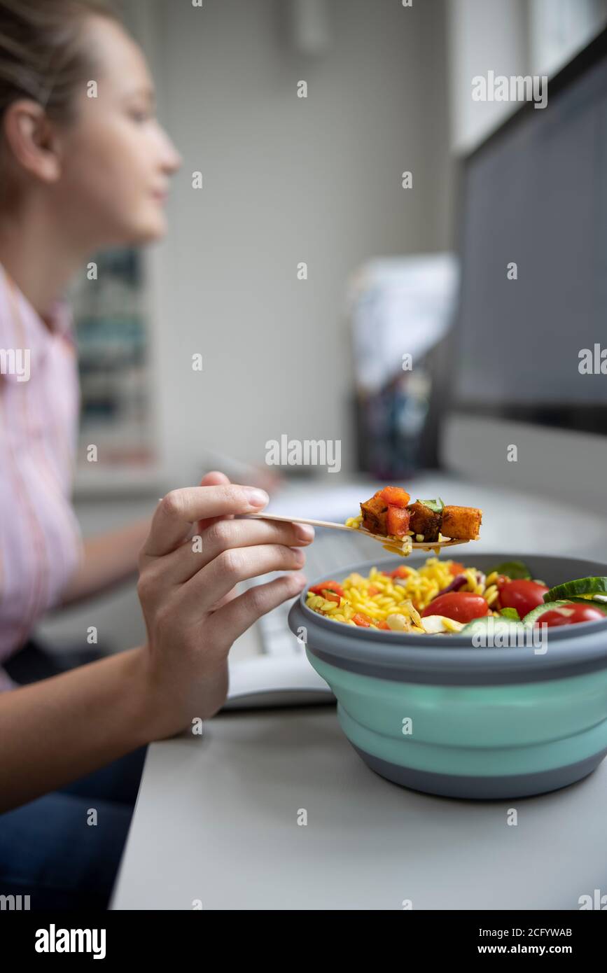 Weibliche Mitarbeiterin Im Büro Mit Gesunden Vegan Mittagessen An Der Rezeption Stockfoto