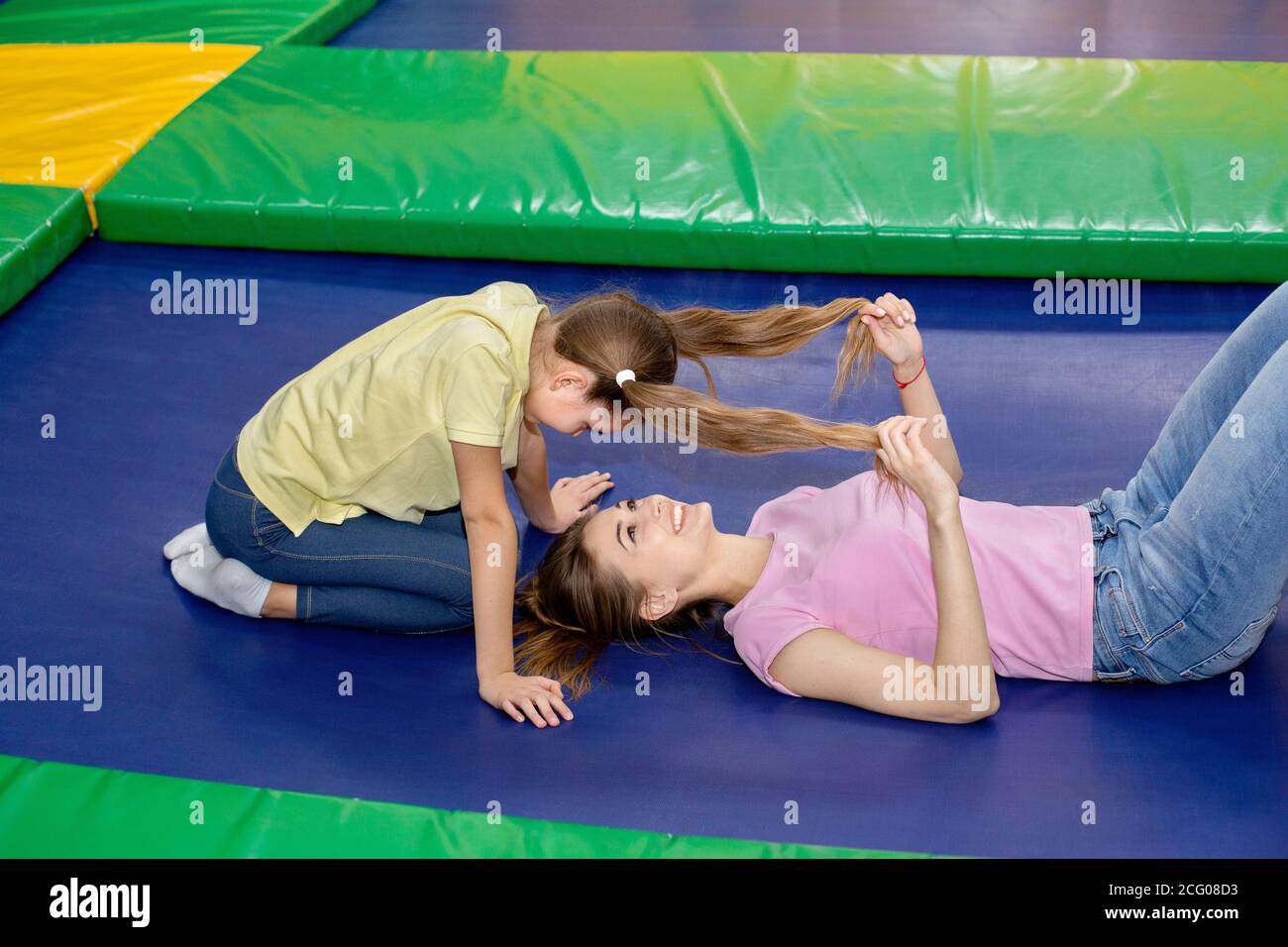 Ideen für Familienurlauber. Glückliche Mutter, die tolle Zeit mit ihrer Tochter im Indoor Trampolinpark hat Stockfoto