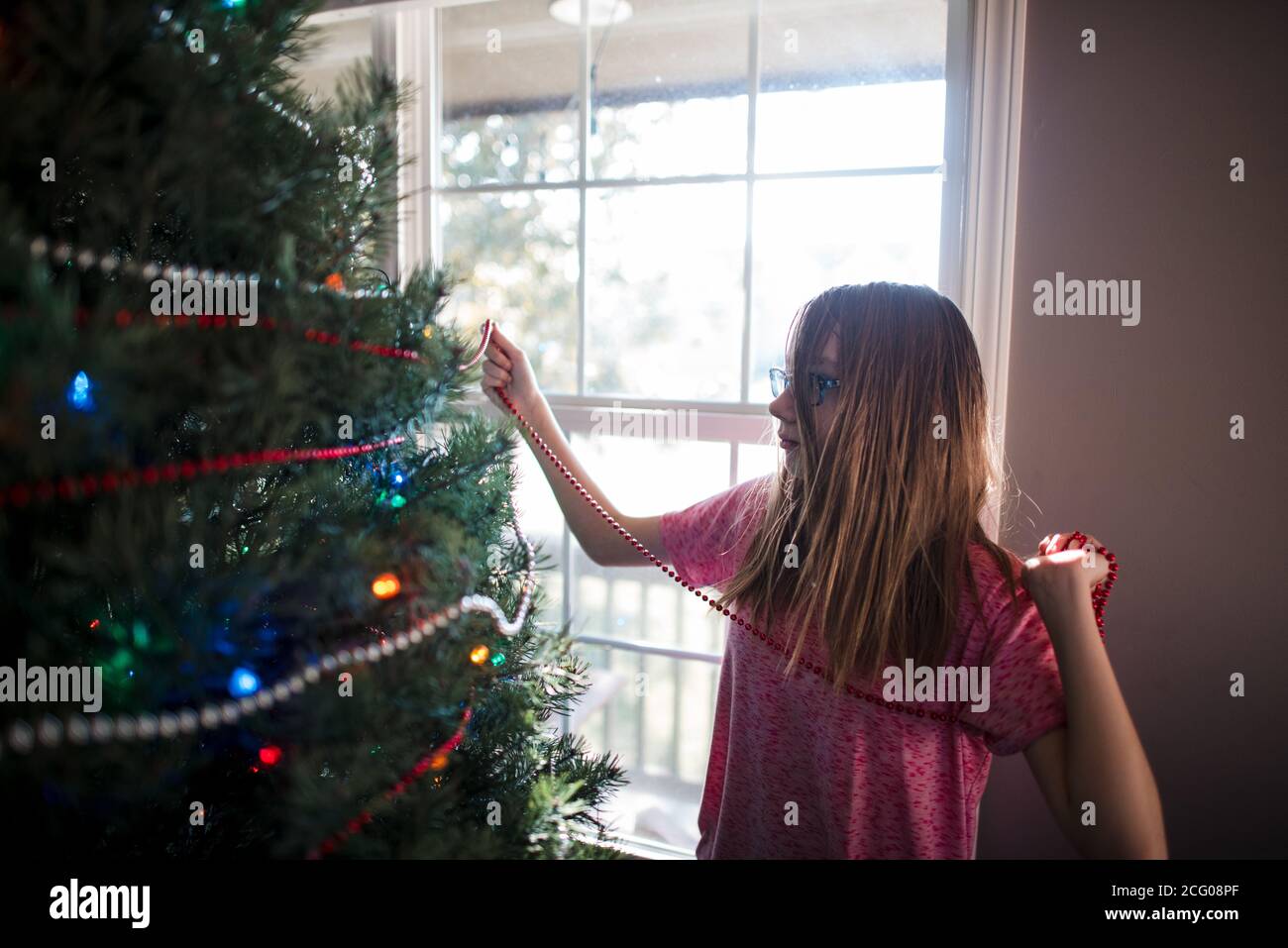 Pre teen Mädchen Dekoration weihnachtsbaum zu Hause Stockfoto