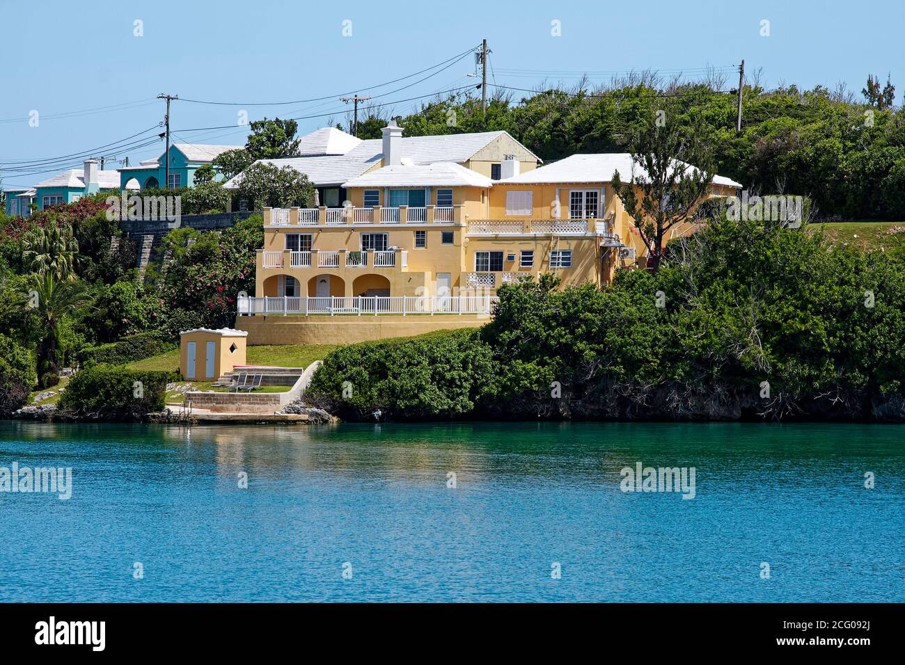 Haus auf dem Wasser, mehrstufig, Dock, Balkone, Pfirsich Farbe, weiß trimmen, Wohnungen Dorf; Bermuda Stockfoto