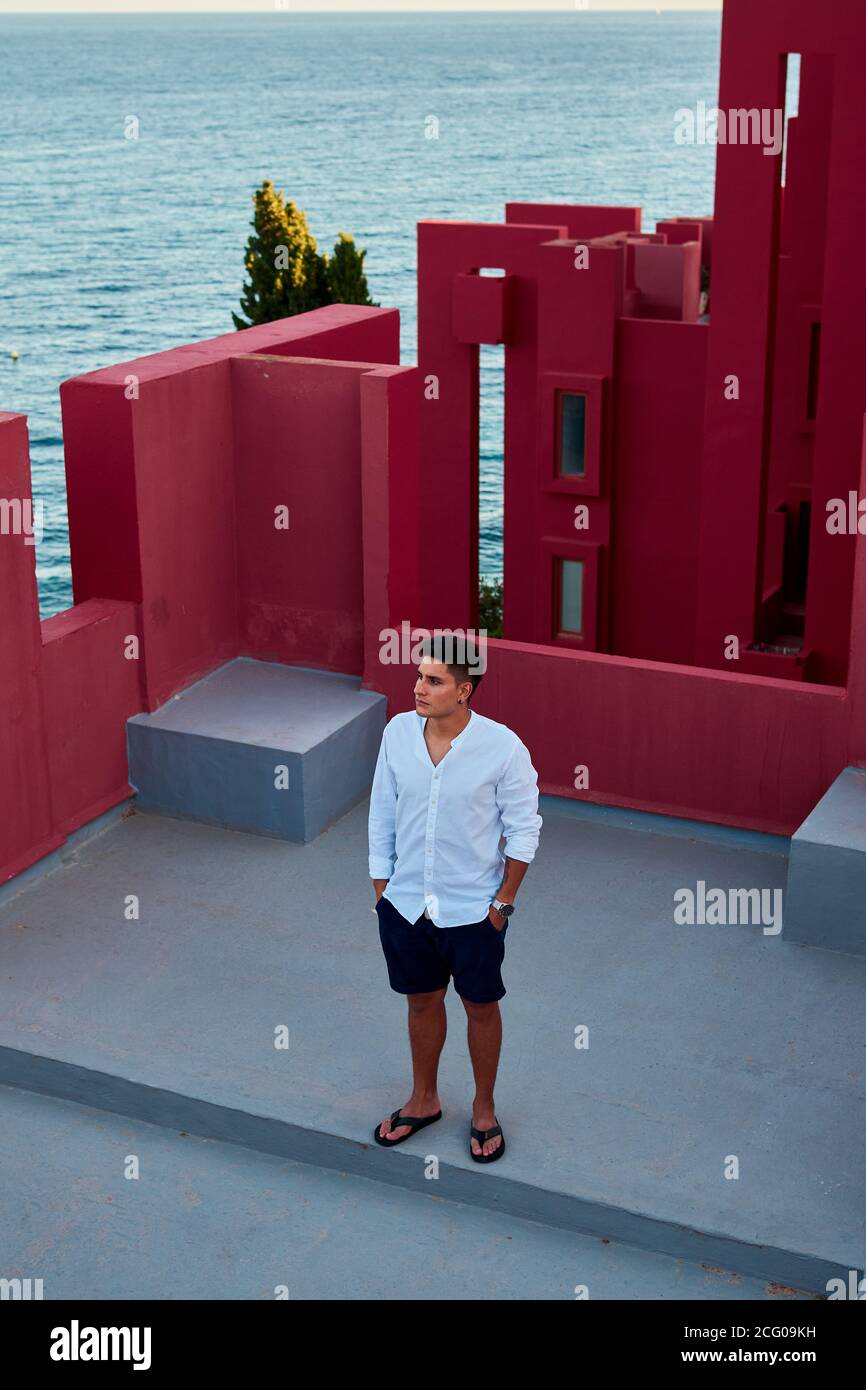 Junger lateinischer Mann meditativ in 'Muralla Roja' aus Calpe, Spanien Stockfoto