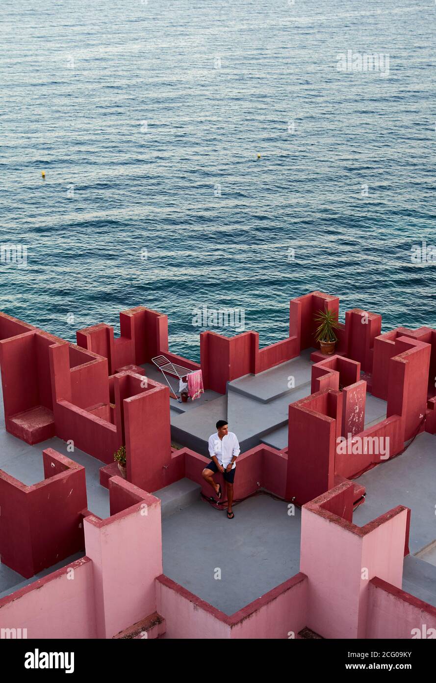 Junger lateinischer Mann meditativ in 'Muralla Roja' aus Calpe, Spanien Stockfoto