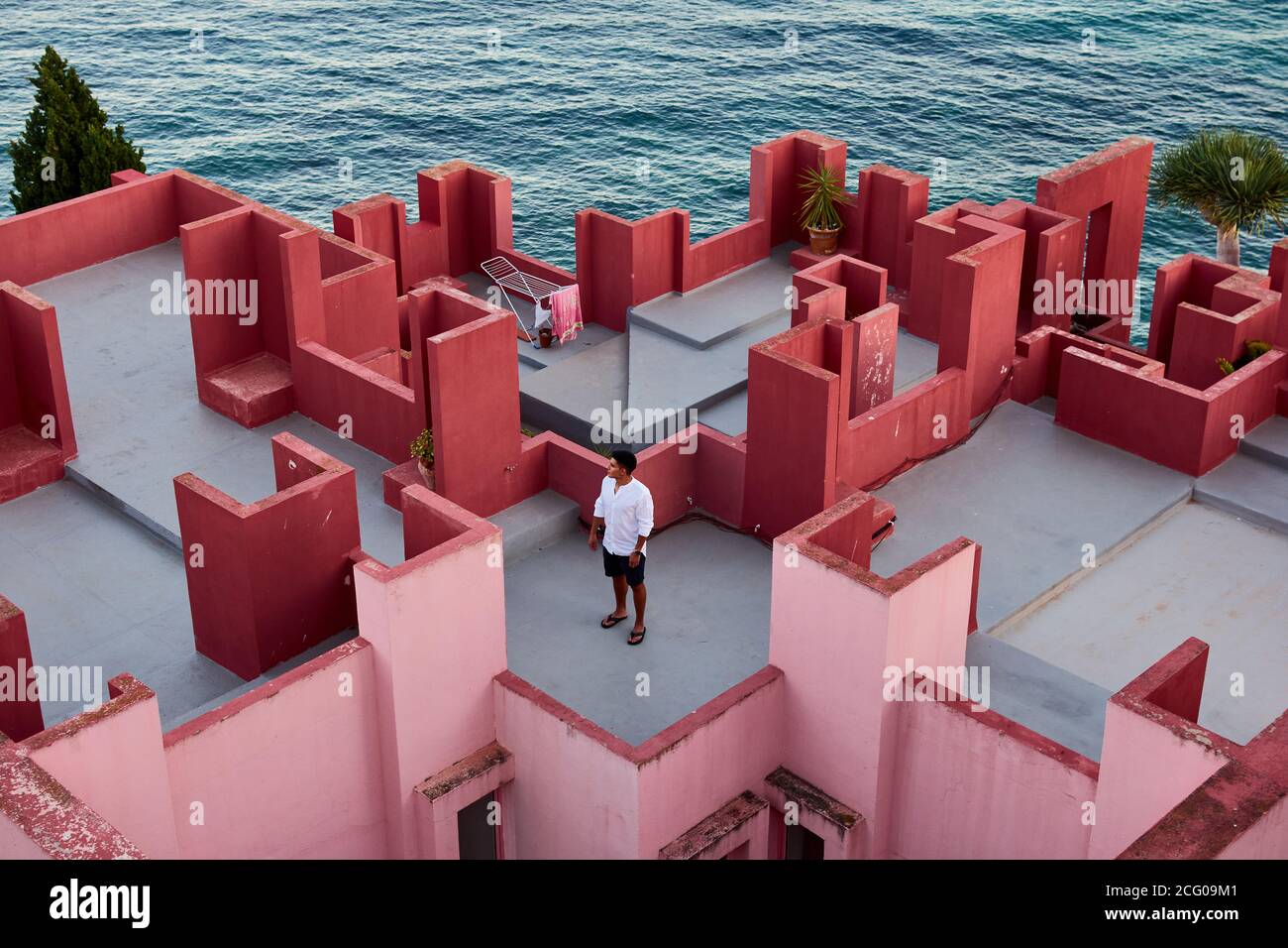 Junger lateinischer Mann meditativ in 'Muralla Roja' aus Calpe, Spanien Stockfoto