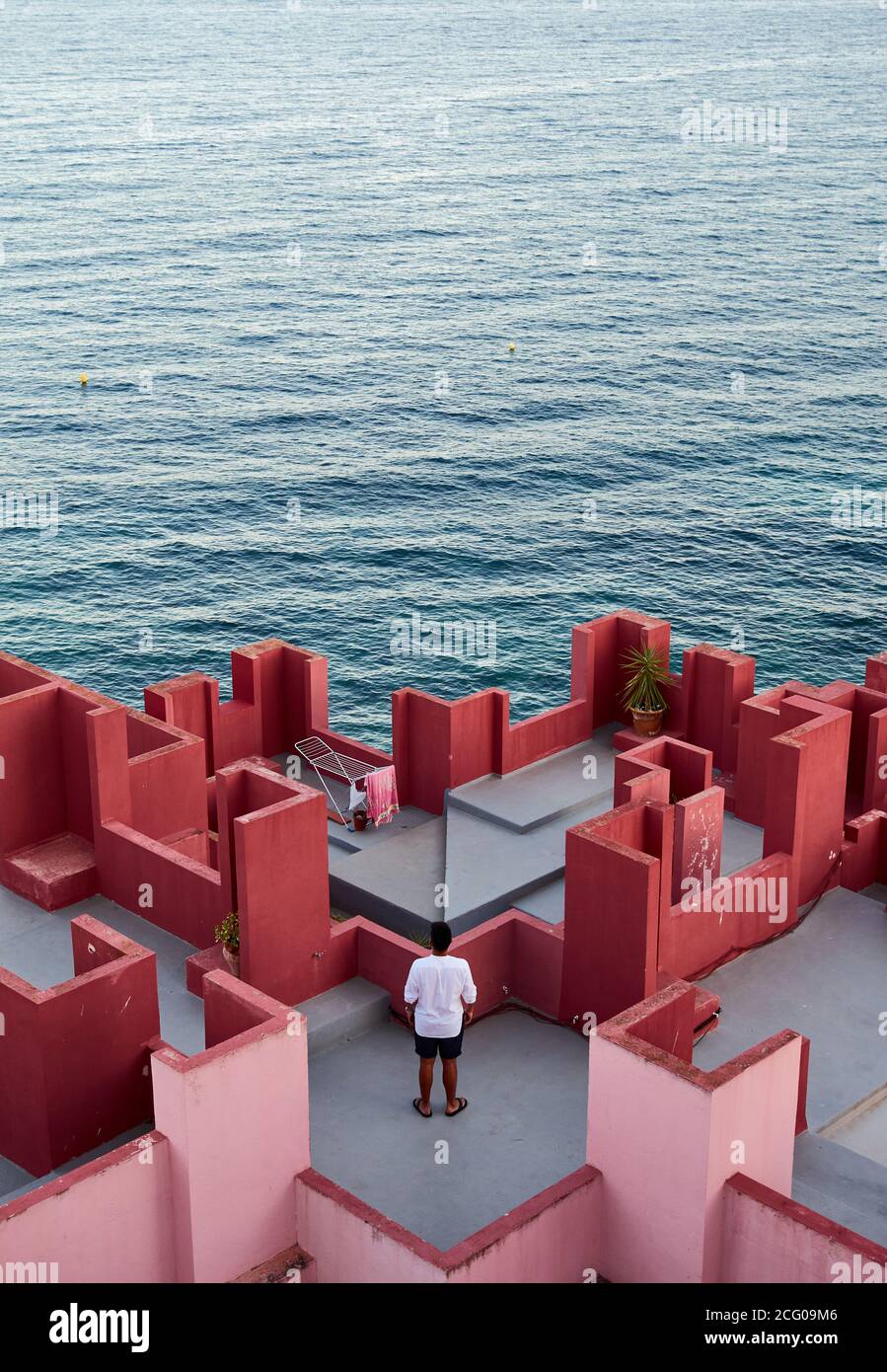 Junger lateinischer Mann meditativ in 'Muralla Roja' aus Calpe, Spanien Stockfoto