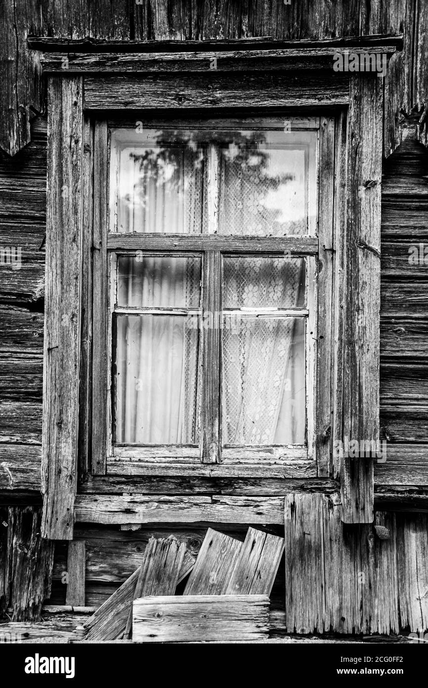 Ein Fenster in einem alten vergessenen Holzhaus. Stockfoto