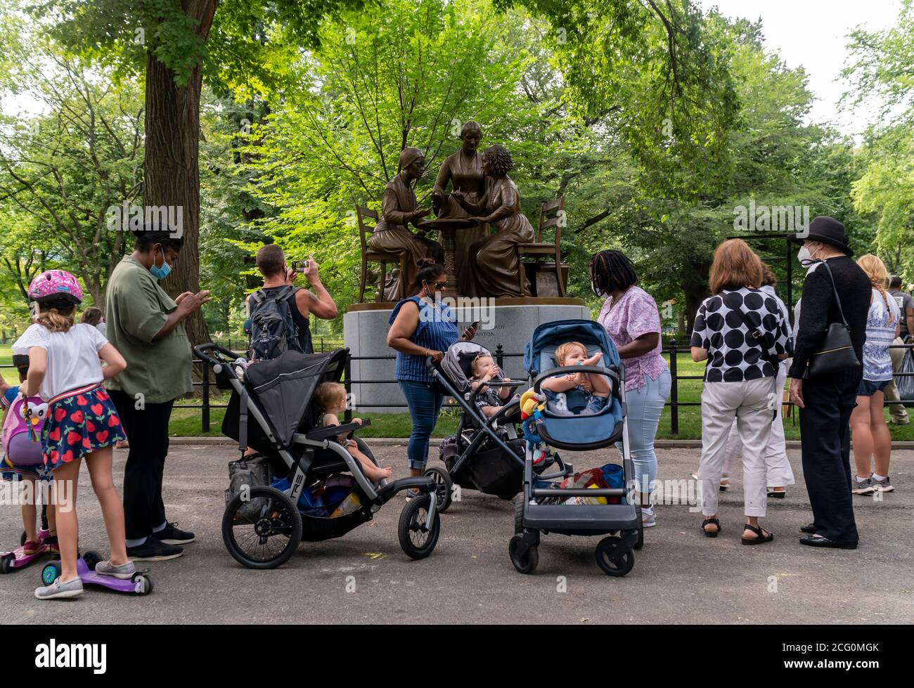 Am Tag der Enthüllung, Mittwoch, den 26. August 2020, finden sich Menschen rund um das Women’s Rights Pioneer Monument auf dem Literary Walk im Central Park in New York zusammen. Die Statue von Sojourner Truth, Susan B. Anthony und Elizabeth Cady Stanton, von links nach rechts, erinnert an den 100. Jahrestag der 19. Änderung, die Frauen das Wahlrecht einbrachte. Der Bildhauer Meredith Bergmann ist das einzige Denkmal im Central Park, das echte Frauen darstellt. (© Richard B. Levine) Stockfoto