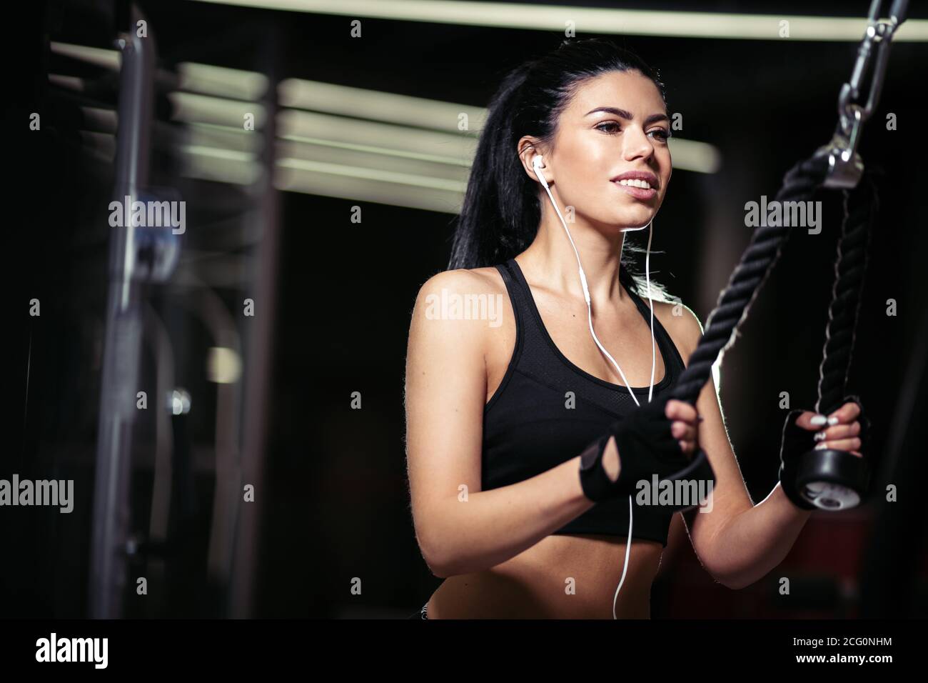 Sport Frau tun Übung in crossover Maschine in der Turnhalle Stockfoto