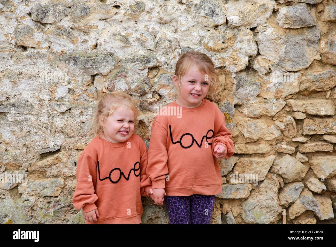 Portrait von zwei kleinen Schwestern in passenden Springer. Stockfoto