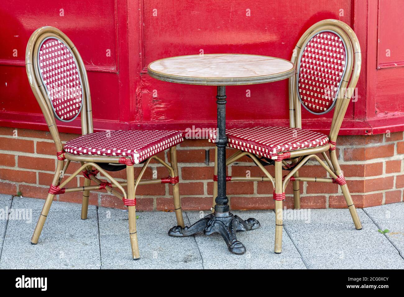 Zwei leere Essstühle an beiden Seiten eines Tisches draußen Ein Restaurant oder Café Stockfoto